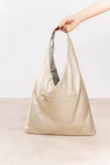 Bolso hobo reversible color azul marino, con textura símil cuero y correa bandolera extraíble.