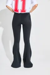 Calza negra de lycra gruesa, tiro alto, corte oxford con tajo en los laterales externos y cintura ancha.