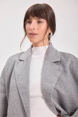 Tapado gris de lana con doble botonadura, cuello con solapas y bolsillos laterales.