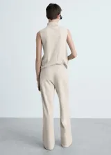 Pantalón de punto color beige, de corte wide leg, tiro medio y cintura elástica.