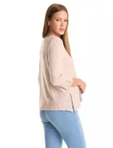 Buzo de tejido suave color beige, con cuello a la base y mangas 3/4 con aplique de botones dorados. Presenta terminación con tajos en los laterales.
