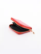 Billetera de color rojo con textura, cierre con cremallera y diseño compacto.