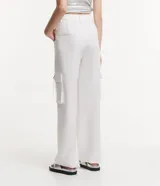 Pantalón de vestir blanco, de corte recto, con bolsillos cargo laterales y detalle de aro metálico en la trabilla.