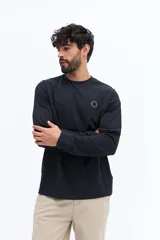 Remera de manga larga color negro, con escote redondo y un pequeño logo circular estampado en el pecho.