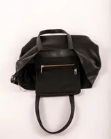 Tote negra amplia de cuero vacuno, diseñada para la mujer moderna, con bolso separador extraíble para mayor organización.