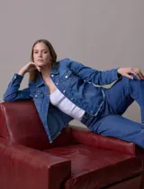 Campera de jean azul de la marca Baccini, con cuello solapa, abertura central con botones metálicos, bolsillos delanteros y ruedo desflecado.