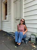 Top sin mangas con cuello redondo y diseño ajustado con frunces elásticos a cuadros rojos y blancos.