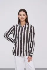 Camisa de manga larga con estampado a rayas verticales en tonos negro, blanco y verde claro.