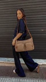 Bandolera de tafeta impermeable, liviana, con dos compartimientos principales, dos bolsillos con cierre y correa regulable con hebilla.