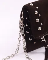 Bandolera de cuero color bordó con tachas plateadas y correa de cadena metálica desmontable.