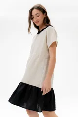 Vestido corto de algodón a rayas horizontales color beige, con cuello redondo negro y falda negra de lino.