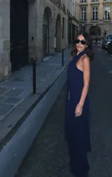 Mono largo color celeste, con escote halter cruzado, corte ajustado en la cintura y detalle de flecos largos en los laterales.