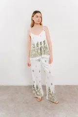 Pantalón blanco con estampado geométrico en azul y marrón, de calce relajado y caída fluida.