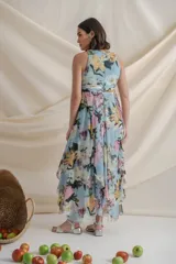 Vestido largo de crepe de seda estampado con flores en tonos celeste, rosa y verde. Tiene cintura drapeada y falda con paneles sueltos.