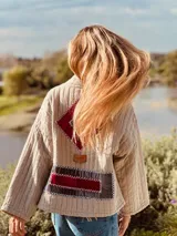 Campera capitoneada color beige con figuras geométricas bordadas a mano en terciopelo color borgoña.