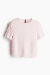 Remera rosa de punto fino con cuello redondo y mangas cortas.