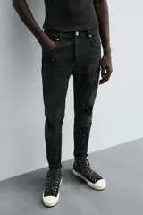 Pantalón de jean celeste de corte skinny con roturas en las rodillas y terminación desflecada.