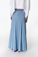 Falda midi tejida a rayas verticales en tonos celeste y azul, con cintura elástica y abertura lateral.