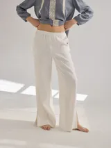 Pantalón color crudo de lino, corte recto con cintura elastizada y tajos laterales en el ruedo.