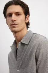 Camisa gris de manga corta en tejido piqué con cuello inglés, tapeta lisa, canesú en la espalda y bajo recto con aberturas laterales.