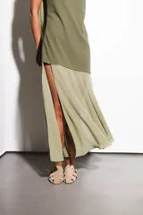 Vestido largo verde oliva, con base de crepé asimétrico y capa de gasa. Incluye capa a juego que se puede usar como chal o corbatín.