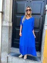 Vestido largo azul eléctrico con escote en V, mangas cortas con detalle de lazo y falda con volantes.