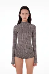 Conjunto de top de cuello alto y shorts ajustados con estampado geométrico en tonos beige y negro.