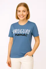 Remera blanca de algodón con estampado frontal que dice 'URUGUAY noma!' en letras azules y negras.
