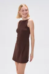 Vestido marrón ajustado al cuerpo, con cuello a la base y sin mangas.