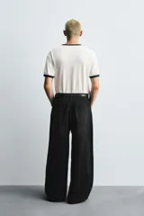 Pantalón de jeans de algodón, corte baggy fit, tiro medio, con efecto lavado en tonos grises y verdes. Presenta cinco bolsillos y cierre frontal con cremallera y botón.