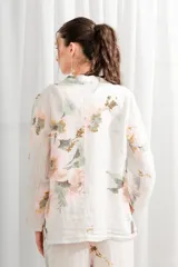 Blazer de lino blanco con estampado floral en tonos rosa y verde, corte holgado, cuello solapa y bolsillos laterales.