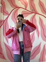 Campera rosa de plush con mangas rojas y capucha de peluche forrada en polar.