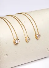 Cadena dorada con dije circular con una zirconia blanca engarzada.