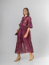 Falda larga confeccionada en organdí de algodón italiano color bordó. Presenta una cintura ancha elastizada con técnica de nido de abeja y un diseño con volado en el ruedo que aporta movimiento.