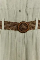 Vestido camisero midi color verde claro, con cuello solapa, escote pico, manga larga remangada con trabilla y botón, bolsillos delanteros de plastrón, cintura elástica, cierre frontal con botones y cinturón de rafia trenzada con hebilla redonda.