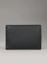 Billetera triple Calvin Klein de cuero sintético texturizado color negro, con logo metálico plateado. Incluye seis ranuras para tarjetas, dos ranuras para billetes y un compartimento para monedas con cremallera.