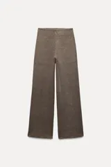 Pantalón marrón de punto canalé con tiro medio, cintura elástica y pierna ancha.