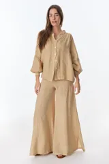 Camisa celeste de lino con botones, mangas largas abullonadas y detalles de crochet en el frente y los puños.