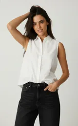Camisa blanca de algodón con bordado calado, cuello camisero, sin mangas y abotonada.