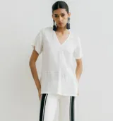 Remera blanca de corte recto con cuello en V y mangas cortas.