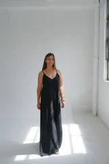 Mono largo negro de viscosa liviana con escote en V y tirantes finos. Espalda descubierta con lazo ajustable.