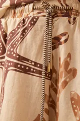 Short de lino color crudo con estampado de motivos marinos en tonos marrones.