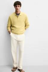 Pantalón chino color crema de corte recto, confeccionado en tejido de algodón con elasticidad. Cuenta con bolsillos frontales y traseros de plastrón con botón. Cierre frontal con cremallera y botón.