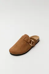 Zuecos negros con base de corcho, puntera cerrada y hebilla dorada decorativa.