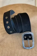 Cinto de cuero negro con textura de pelo, hebilla metálica plateada y ojales metálicos.