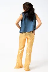 Pantalón largo de cuero sintético verde metalizado, de corte acampanado con aberturas laterales con botones a presión.