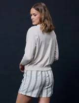 Cárdigan color beige tejido en hilado fino, con escote en V y cierre frontal con un botón.
