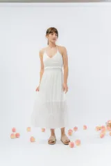 Vestido largo blanco con top tejido en crochet y falda de gasa liviana con caída natural. Escote halter con breteles que atan al cuello y detalle de puntilla en la unión del busto.