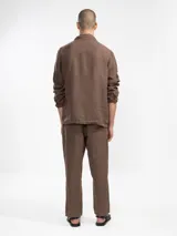 Chaqueta marrón de lino italiano, de corte relajado, con tres bolsillos frontales y cierre con botones.