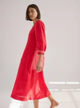 Vestido midi de lino color coral, con escote cuadrado, mangas 3/4 abullonadas y corte suelto.
